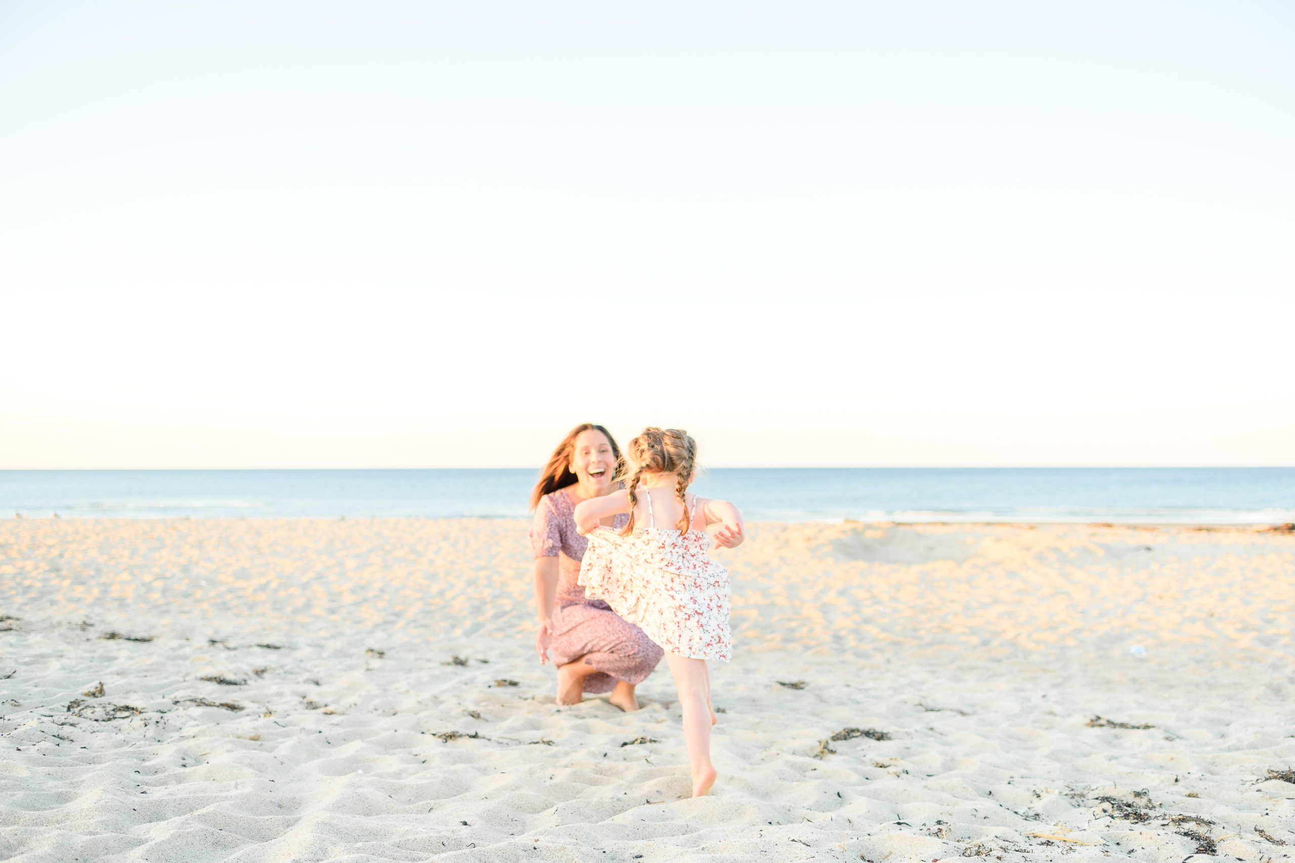 mother and daughter playing at the beach during photoshoot